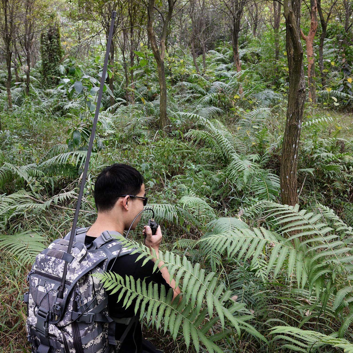 Amateur radio operator using the extended antenna in an outdoor hiking or field operation setting
